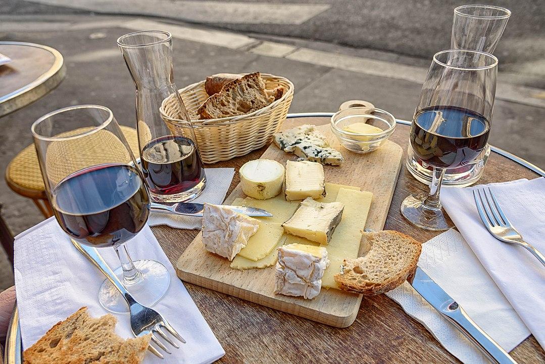 1079px-Cheese,_wine_and_bread_in_a_sidewalk_cafe_in_Paris,_June_2015.jpg