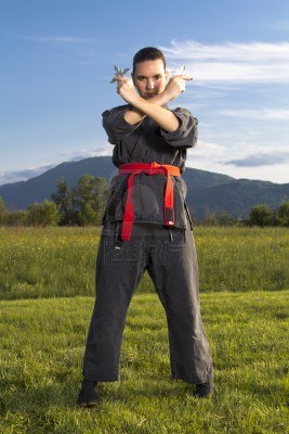 13770022-woman-ninja-in-an-aggressive-posture-with-shuriken.jpg