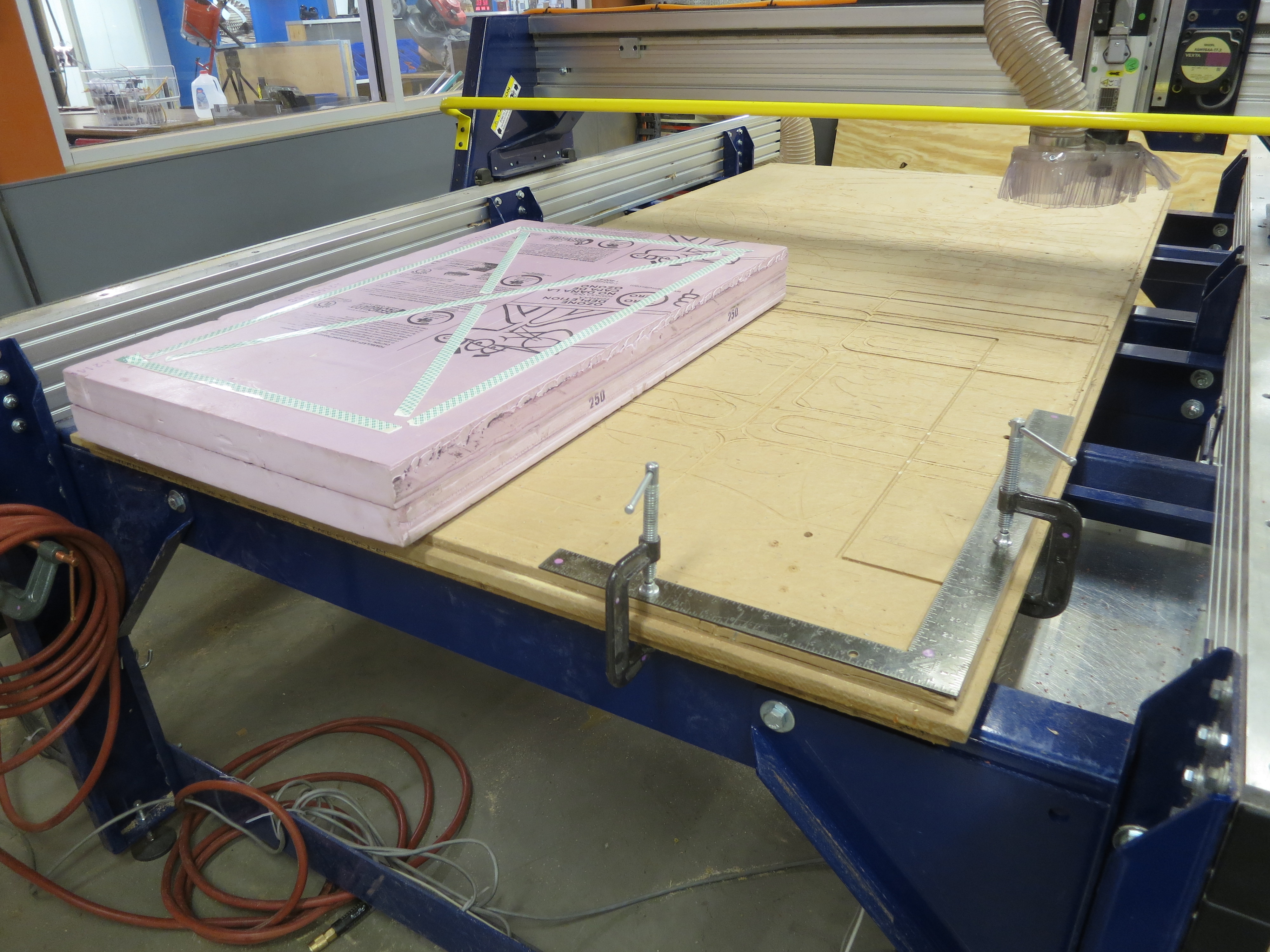 43_Stickin the block of foam down to the CNC router with double sided tape.JPG