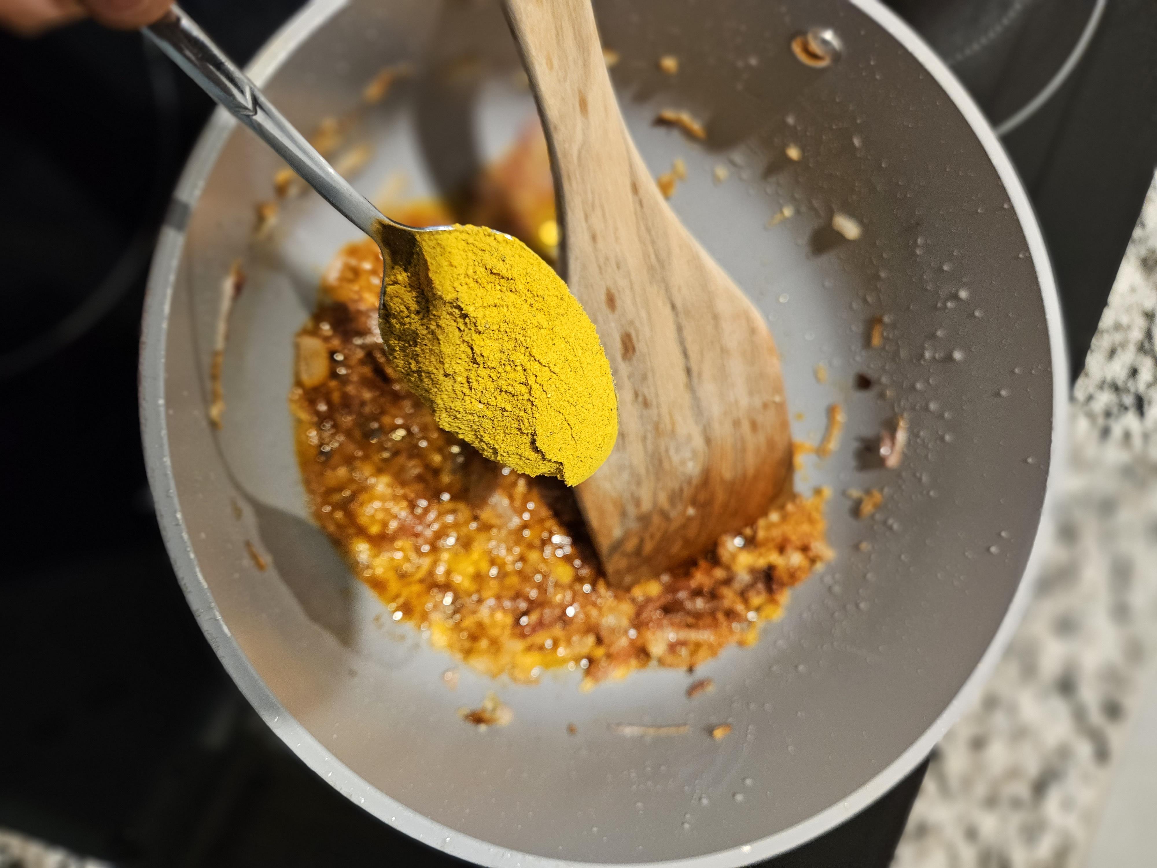 Addingspoonful of curry powder.jpg