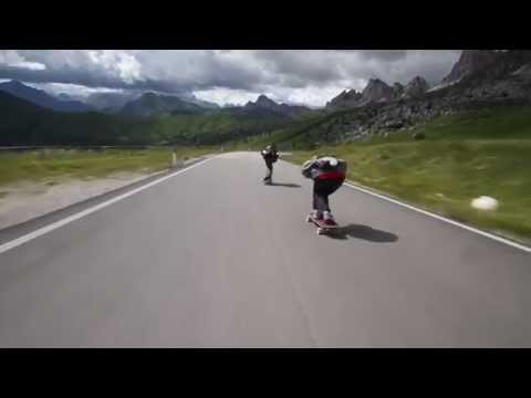 Crazy downhill skateboarders flying by cyclists