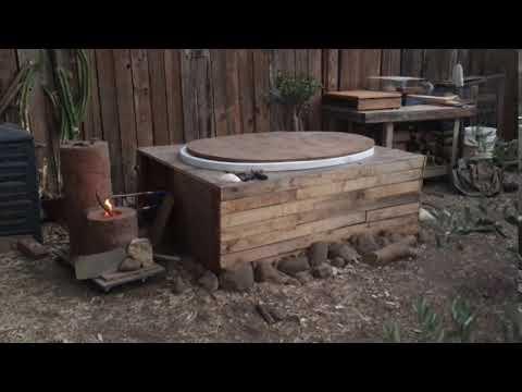 Daytime view of hot tub with rocket stove burning