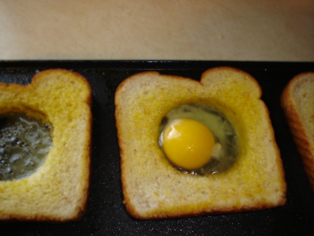 Drop egg into bread hole over melted margarine.JPG