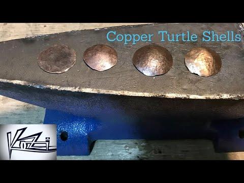 Hammering a copper turtle shell with scrap metal