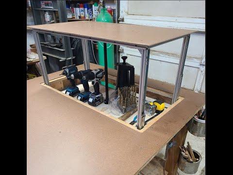 Powered rising shelf for an outfeed table.