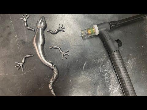 TIG welding the arms and legs to the body of a scrap metal lizard