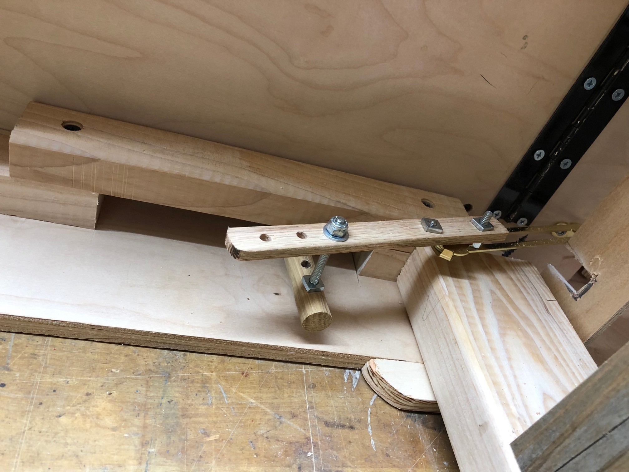 Underneath lever attached to wood extension of lid support hinge.jpg