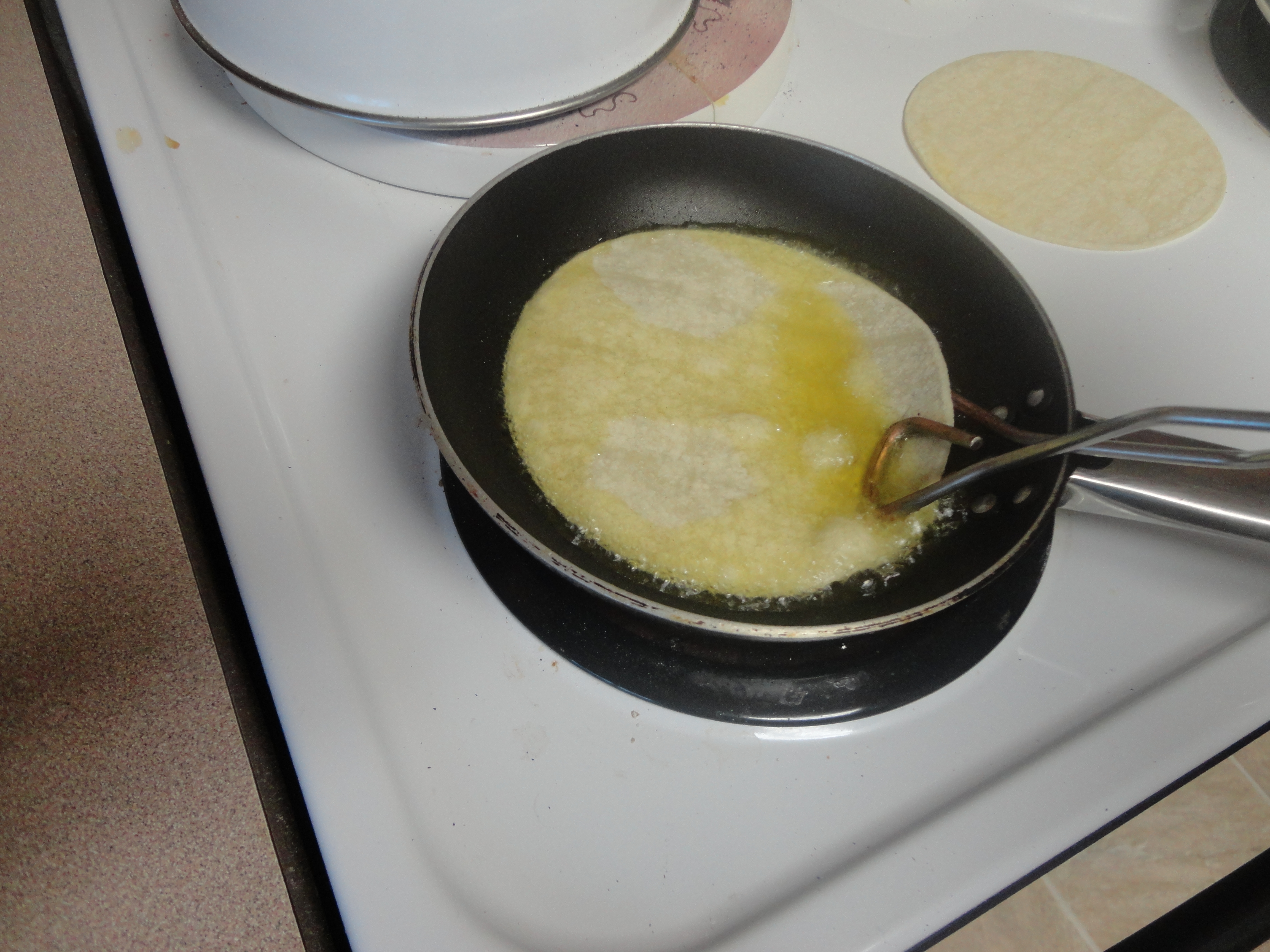 frying tortilla in hot oil.JPG