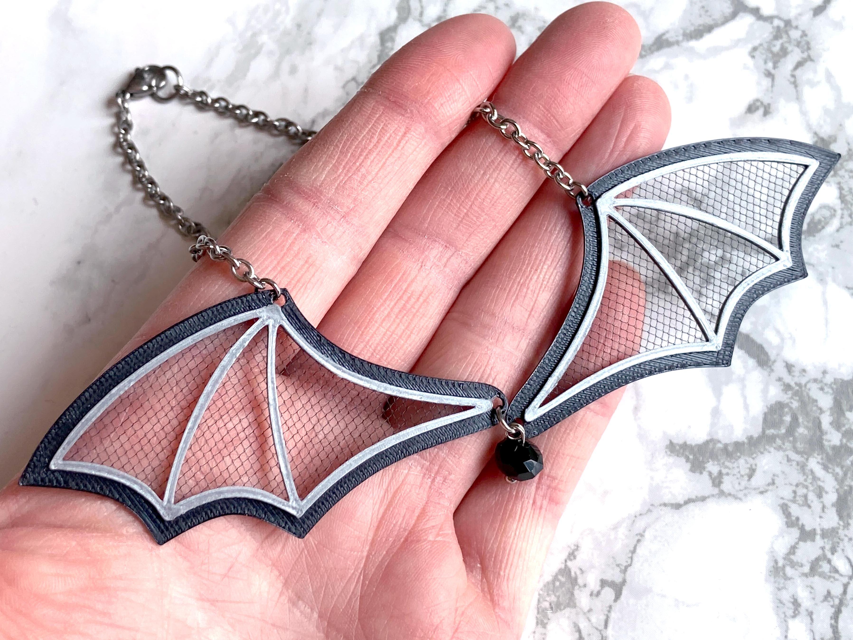 holding bat wing necklace with tulle.jpg