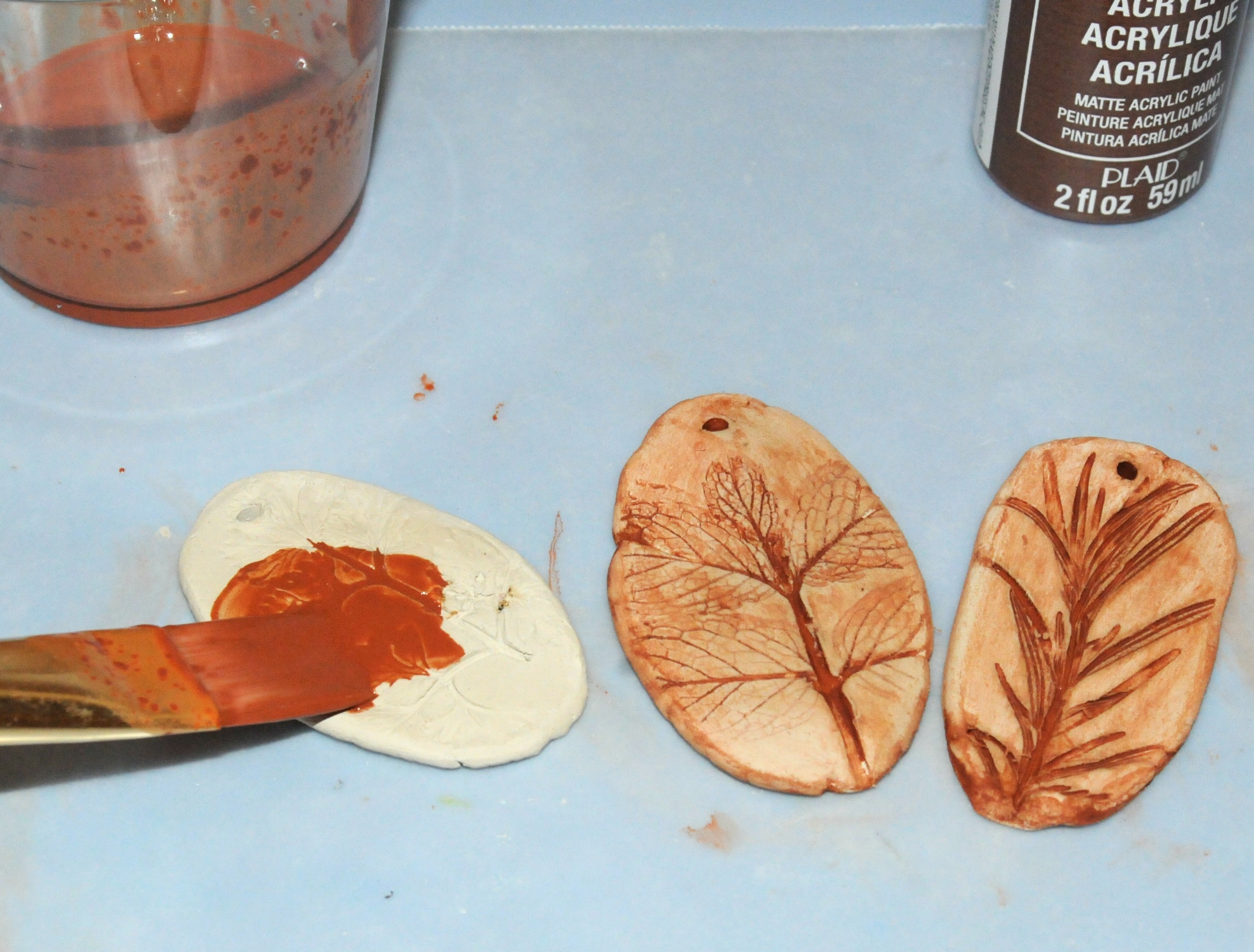 painting air dry clay pendants.jpg