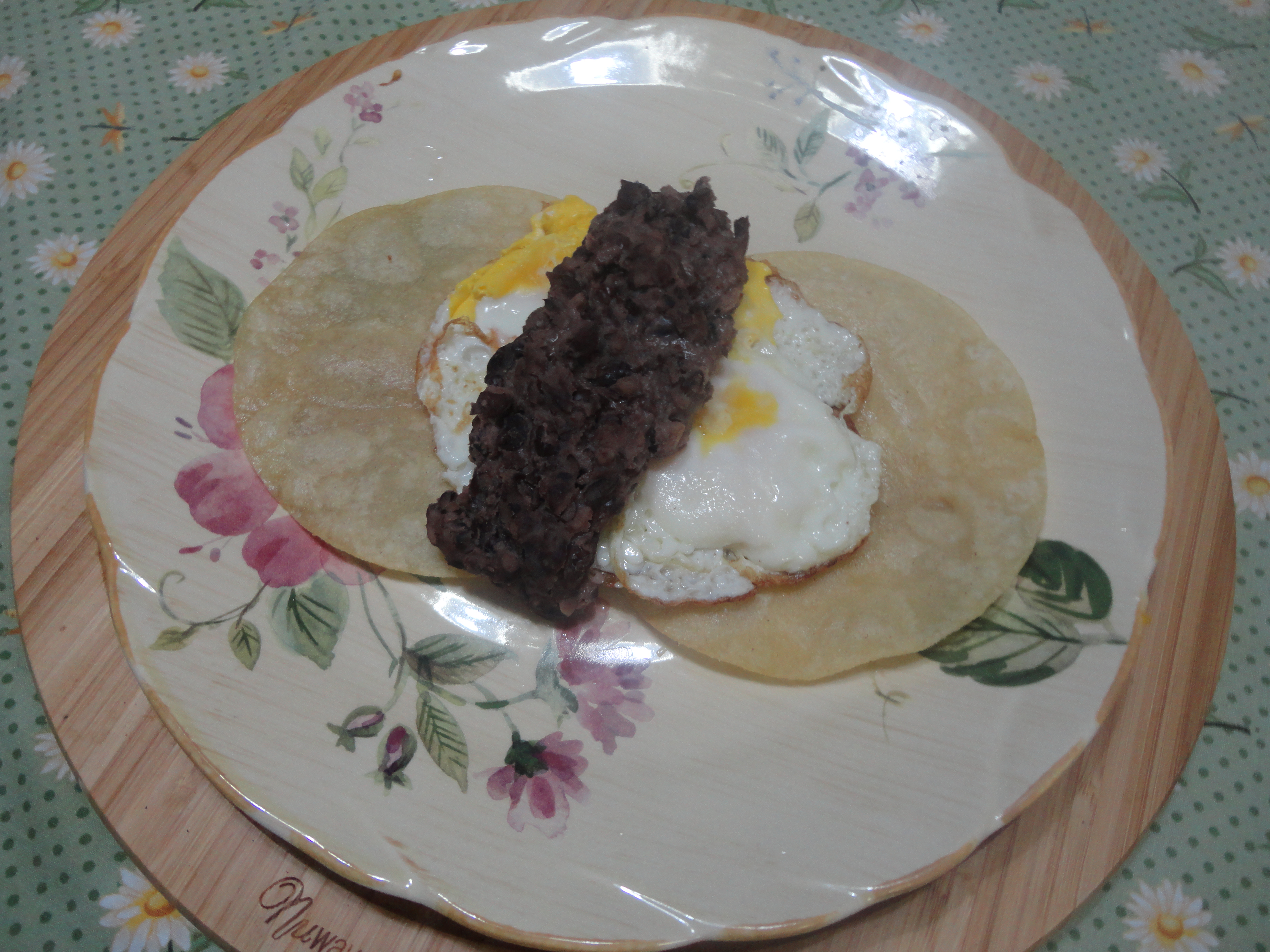 spooning black beans over center of eggs.JPG