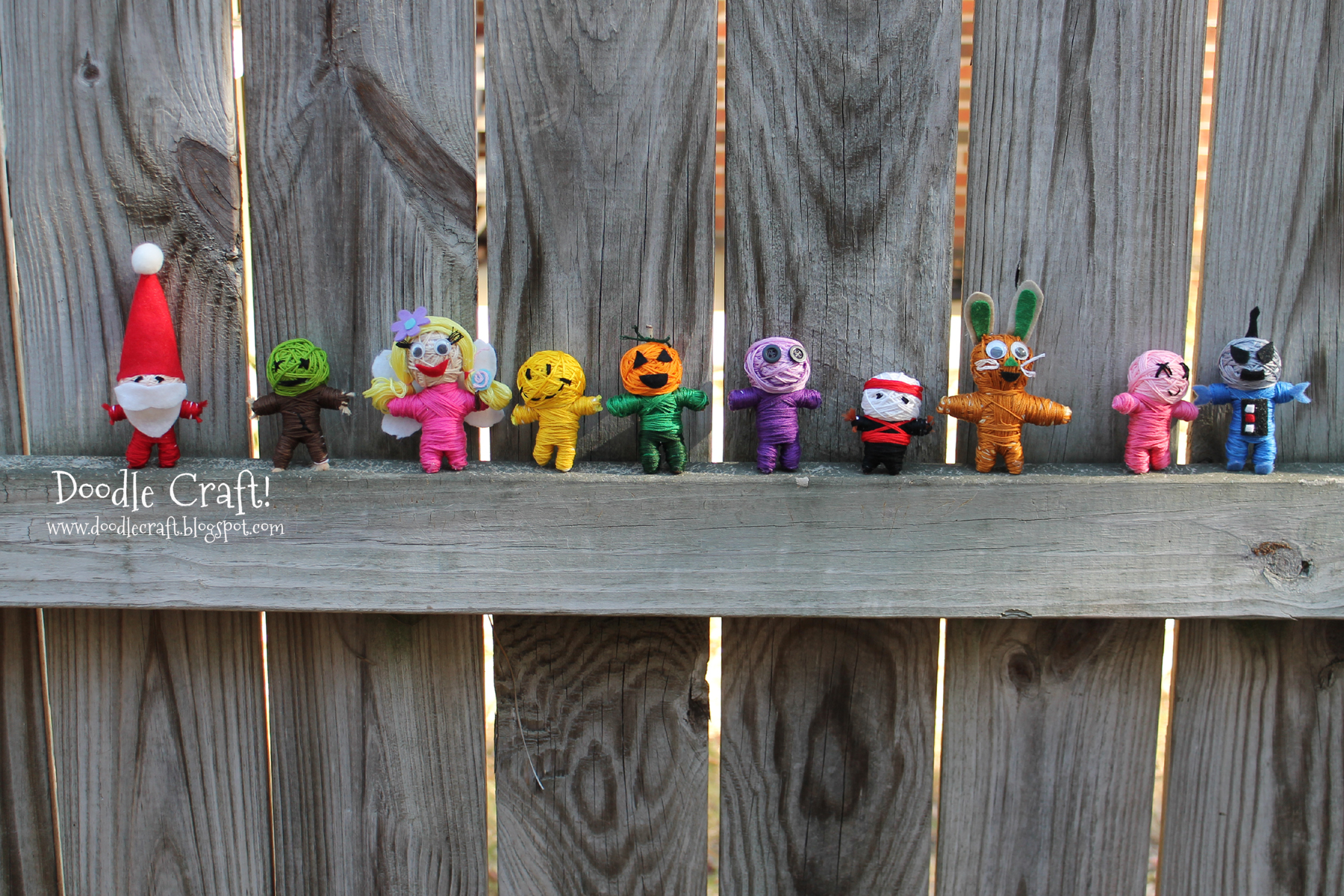 string doll line up on fence.jpg